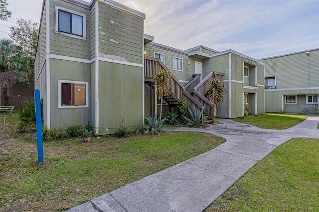 multi unit property with a front lawn and stairway