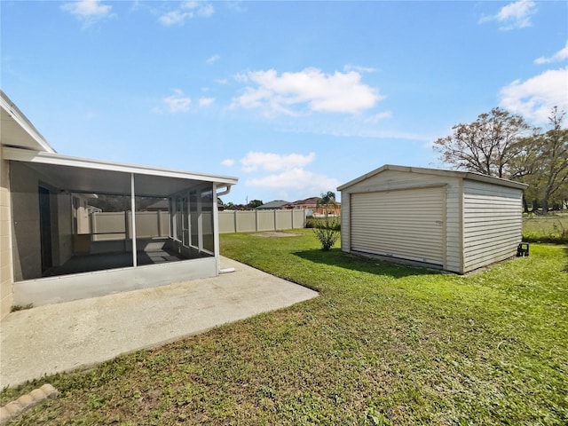 view of yard with a sunroom, an outdoor structure, and fence