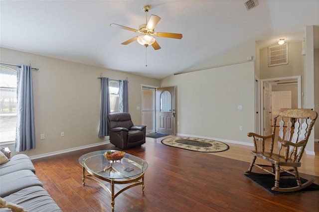 living room with visible vents, wood finished floors, baseboards, ceiling fan, and vaulted ceiling