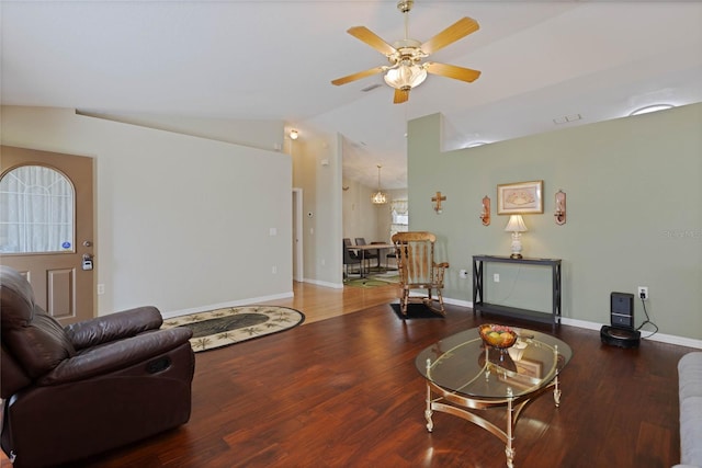 living room featuring visible vents, baseboards, vaulted ceiling, ceiling fan with notable chandelier, and wood finished floors