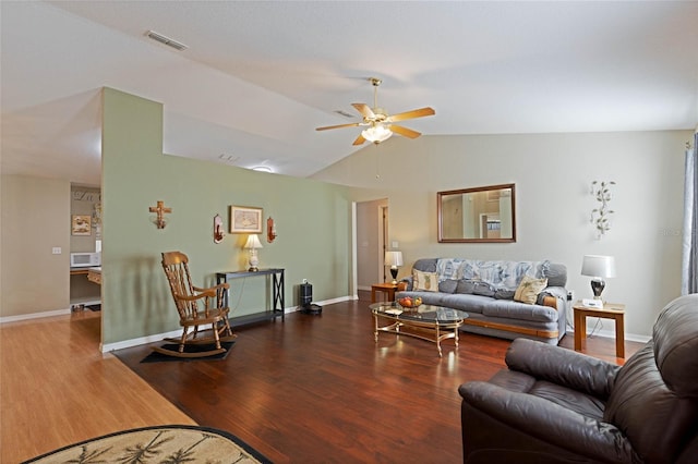 living room featuring visible vents, wood finished floors, baseboards, ceiling fan, and vaulted ceiling