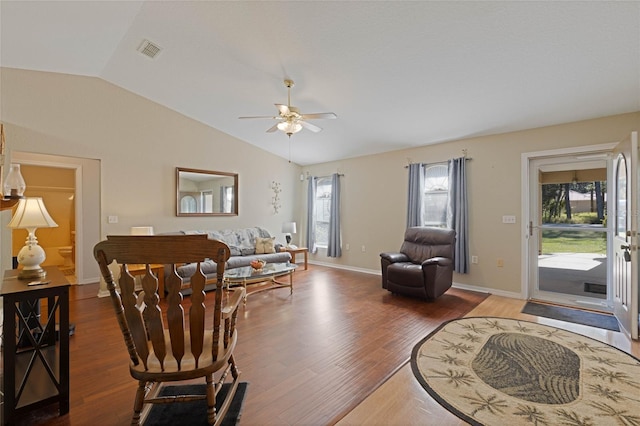 living room featuring visible vents, baseboards, ceiling fan, vaulted ceiling, and wood finished floors