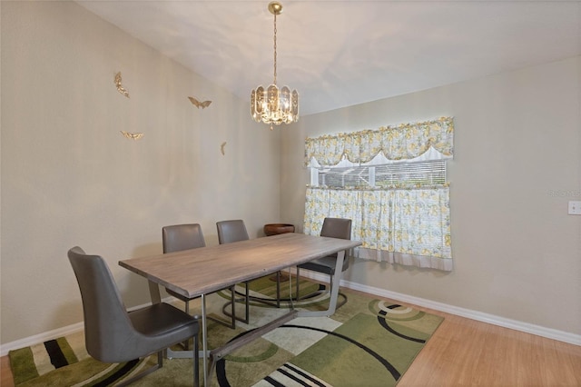 dining space featuring a notable chandelier, wood finished floors, and baseboards