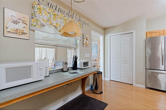 home office with light wood-type flooring and baseboards