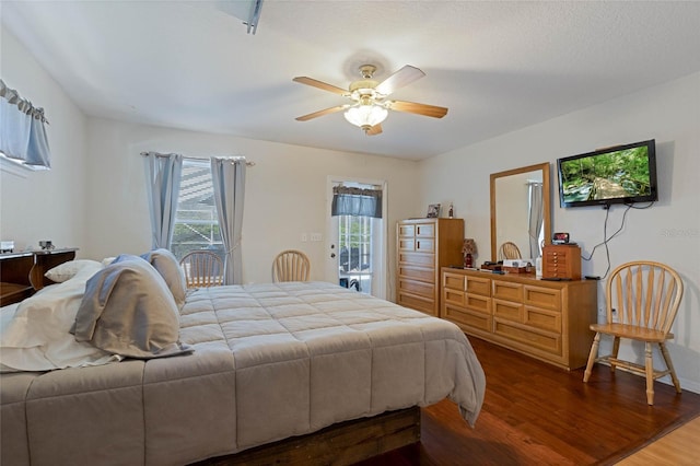 bedroom featuring multiple windows, wood finished floors, a ceiling fan, and access to outside