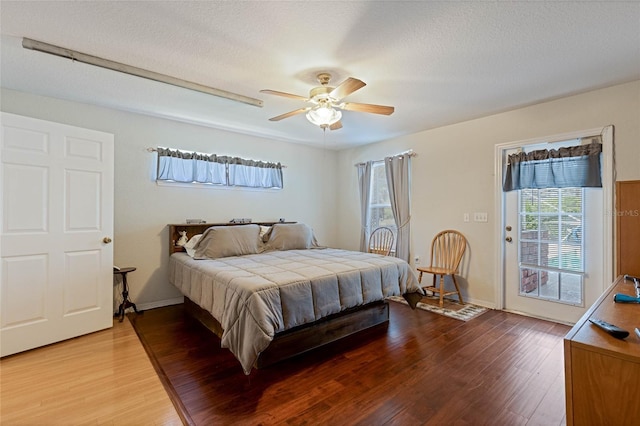 bedroom featuring access to outside, a textured ceiling, ceiling fan, and wood finished floors