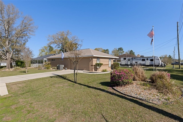 view of front of house featuring a front lawn, central AC unit, concrete driveway, and an attached garage