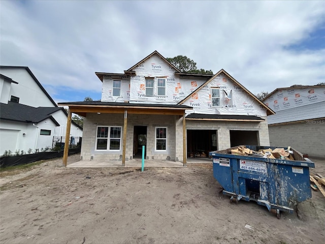 unfinished property featuring an attached garage and concrete block siding