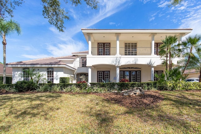 view of front of house featuring french doors, a front yard, a balcony, and stucco siding