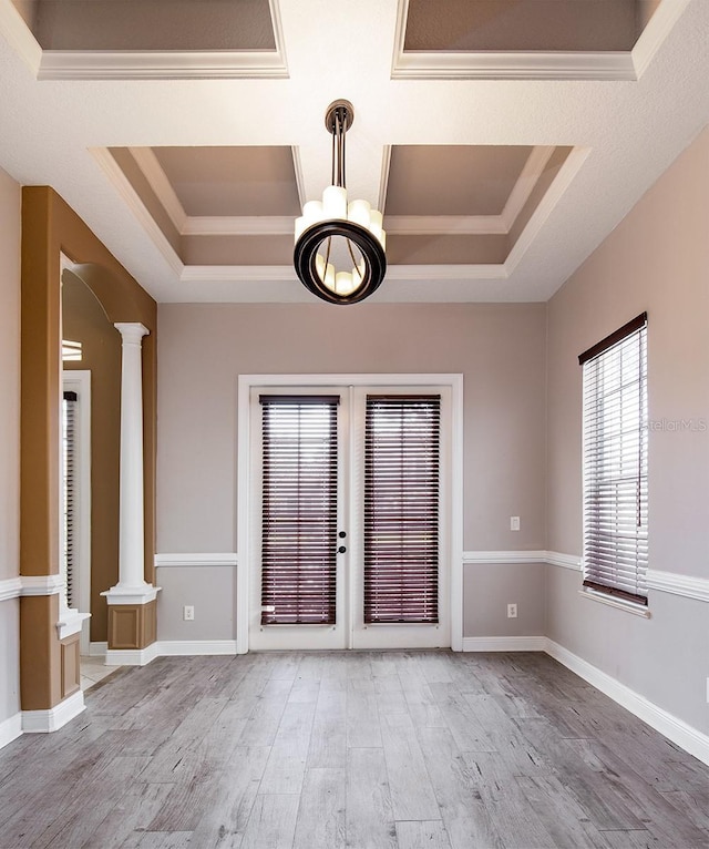 foyer featuring decorative columns, baseboards, wood finished floors, a tray ceiling, and french doors