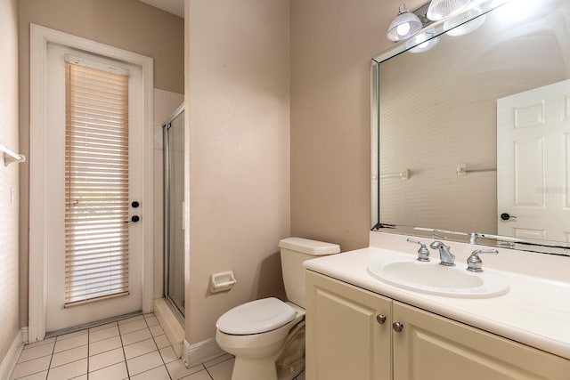 bathroom featuring tile patterned flooring, toilet, vanity, baseboards, and a shower stall