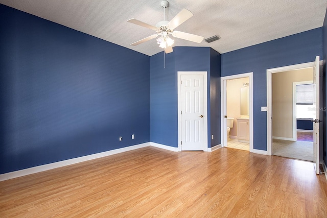 unfurnished bedroom with light wood-style floors, baseboards, visible vents, and a textured ceiling