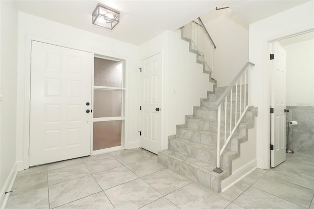 entryway with light tile patterned floors and stairway