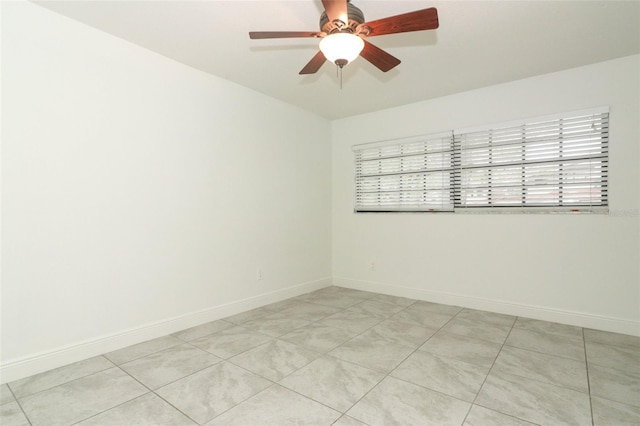 spare room featuring ceiling fan and baseboards