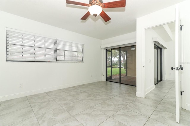 spare room with baseboards and a ceiling fan