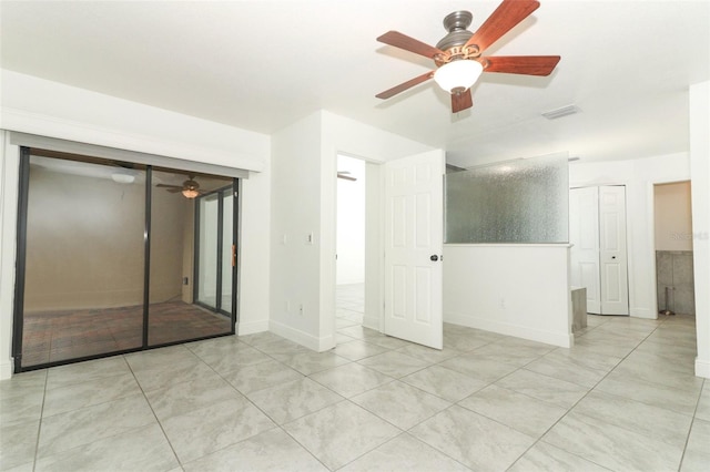 empty room with light tile patterned floors, ceiling fan, and baseboards