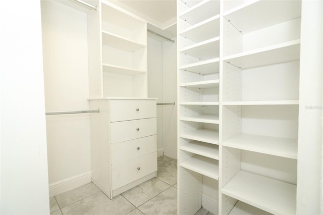 walk in closet with light tile patterned floors