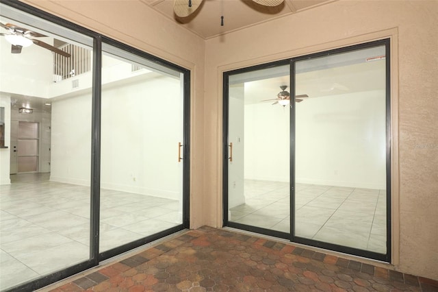 unfurnished sunroom featuring ceiling fan