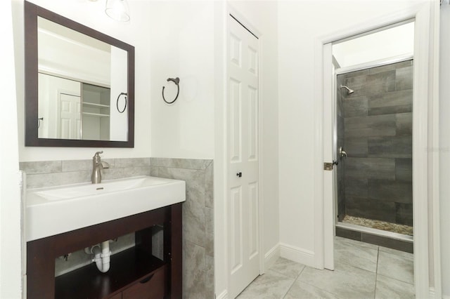 bathroom with tile patterned floors, tiled shower, and vanity