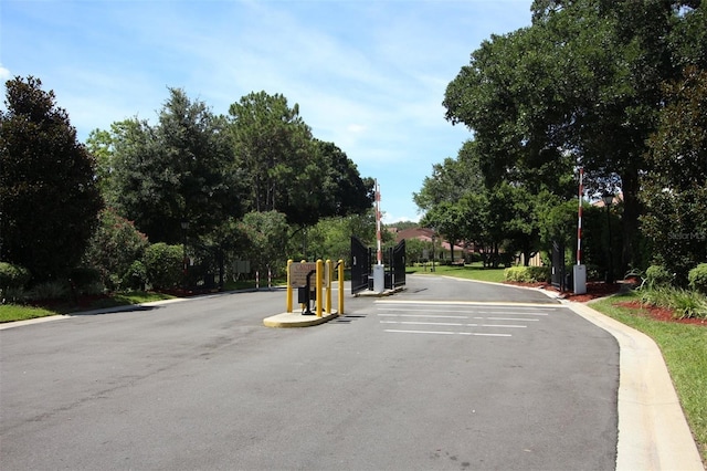 view of street with curbs and a gated entry