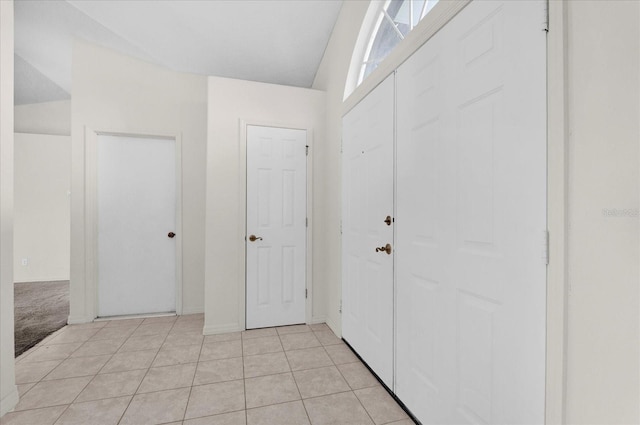 foyer with light tile patterned flooring and baseboards