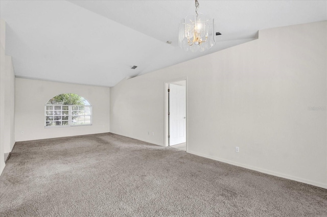 carpeted spare room with an inviting chandelier, visible vents, and lofted ceiling