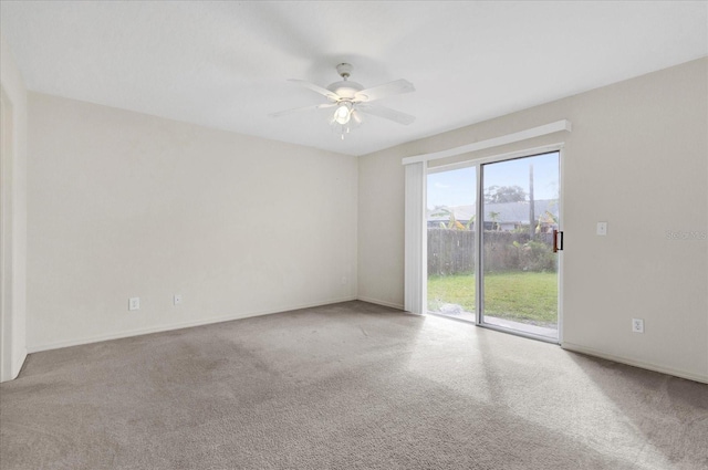 carpeted empty room featuring a ceiling fan and baseboards