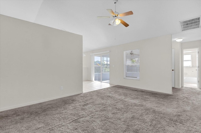 unfurnished living room with visible vents, plenty of natural light, a ceiling fan, and carpet flooring