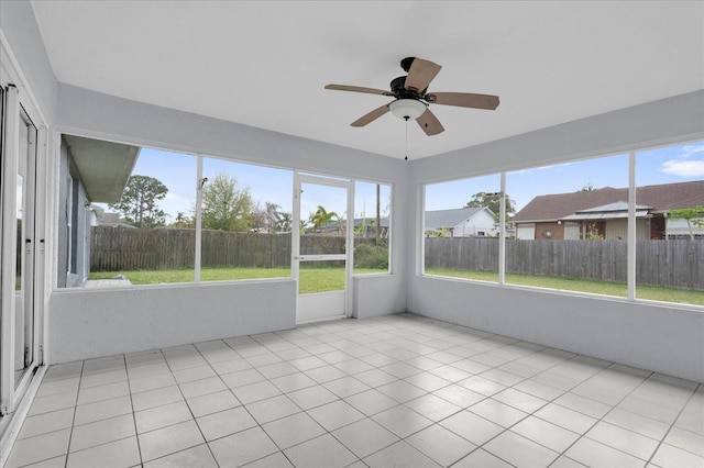 unfurnished sunroom featuring a ceiling fan