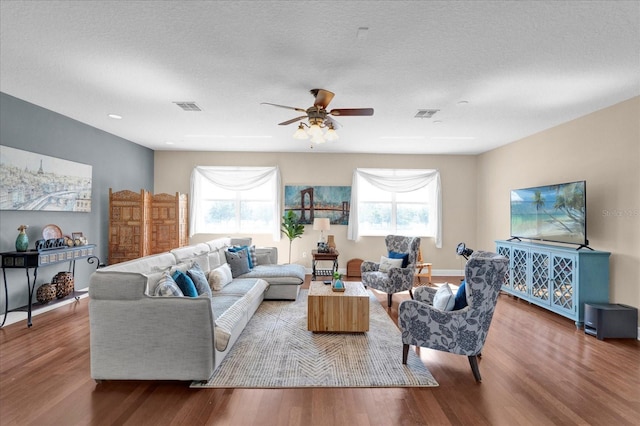 living room with a healthy amount of sunlight, visible vents, and wood finished floors