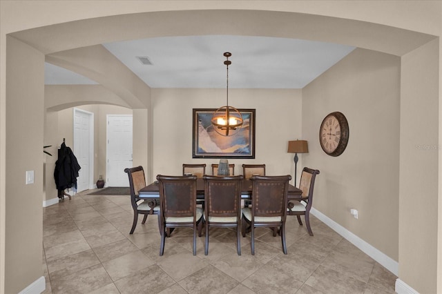 dining area with arched walkways, visible vents, and baseboards