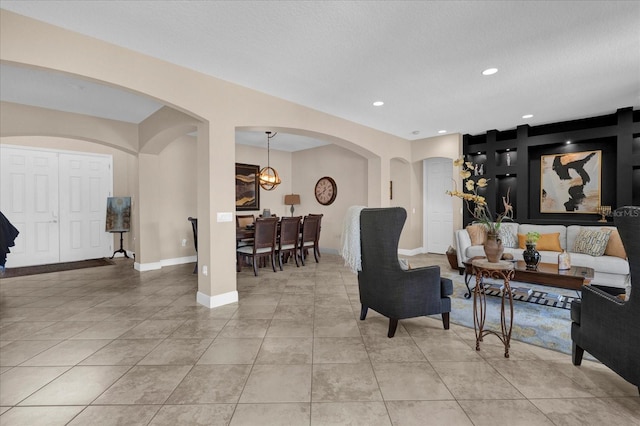 living area with recessed lighting, baseboards, arched walkways, and light tile patterned flooring