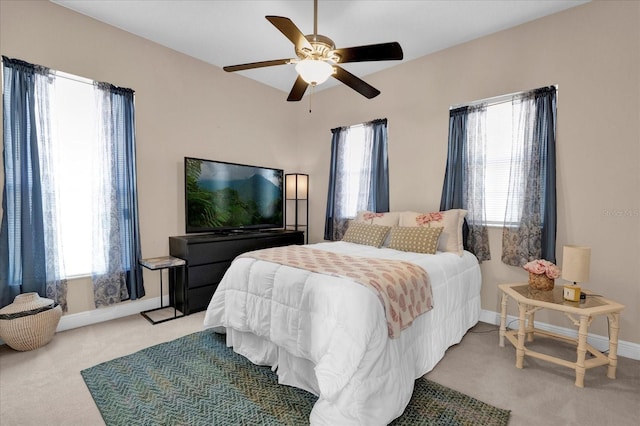 bedroom with light carpet, multiple windows, a ceiling fan, and baseboards