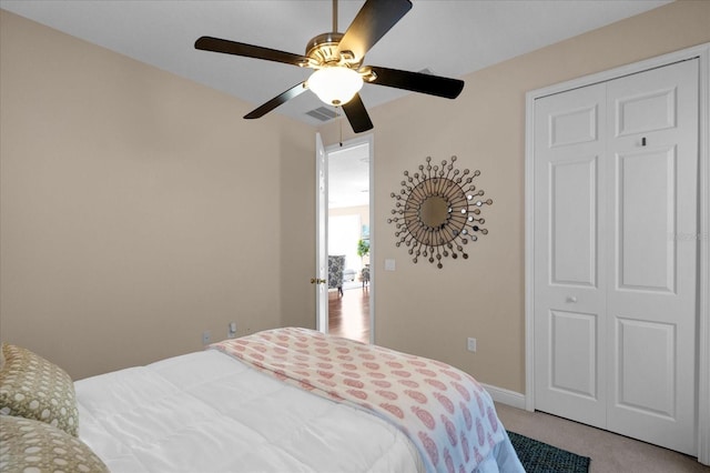 bedroom featuring ceiling fan, visible vents, baseboards, and light colored carpet