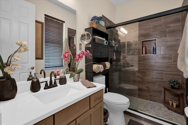 full bath featuring a stall shower, vanity, and toilet