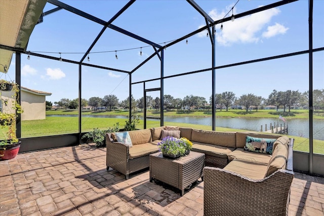 view of patio / terrace with a lanai, a water view, and an outdoor living space