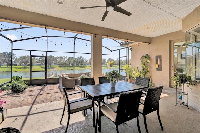 view of patio featuring outdoor dining area, outdoor lounge area, a water view, glass enclosure, and ceiling fan