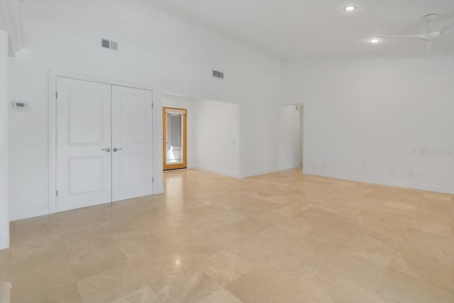 spare room with high vaulted ceiling, visible vents, and baseboards