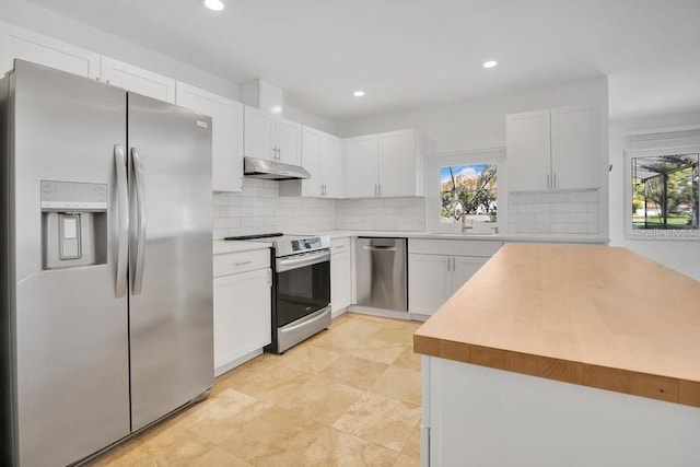 kitchen featuring appliances with stainless steel finishes, a healthy amount of sunlight, under cabinet range hood, and white cabinetry