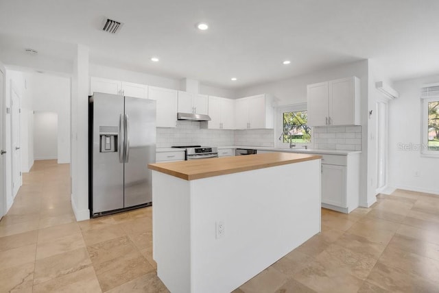 kitchen with stainless steel appliances, a healthy amount of sunlight, visible vents, and under cabinet range hood