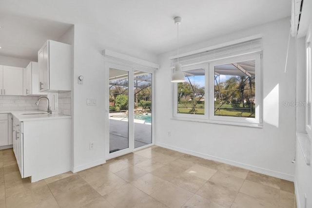 unfurnished dining area with baseboards and a sink