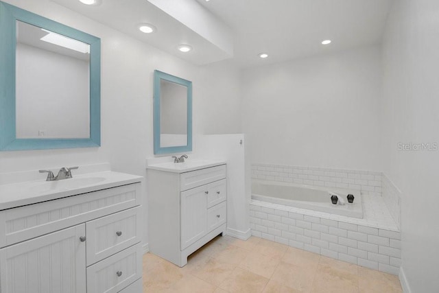 full bath featuring tile patterned floors, two vanities, a sink, and a bath