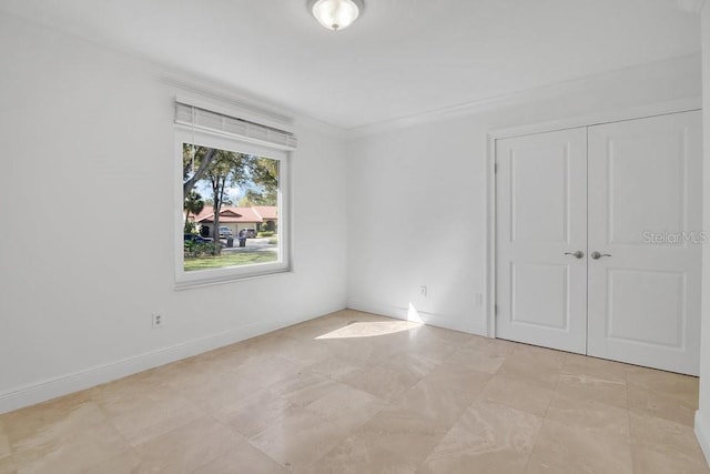 unfurnished bedroom with baseboards and a closet