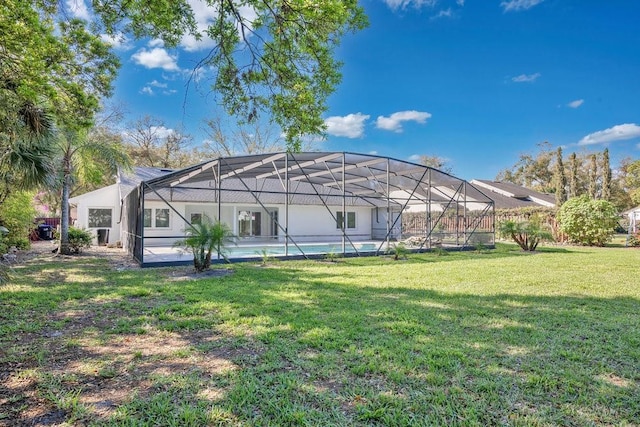 rear view of property featuring a lanai, stucco siding, an outdoor pool, and a yard