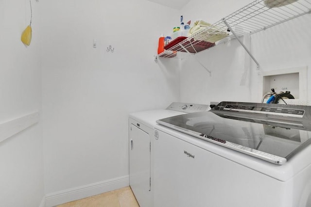 laundry area with laundry area, separate washer and dryer, and baseboards