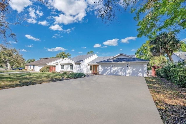 ranch-style home featuring a garage, driveway, and a front lawn