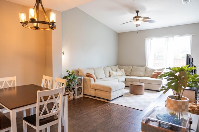 living room featuring dark wood-type flooring, ceiling fan with notable chandelier, and visible vents