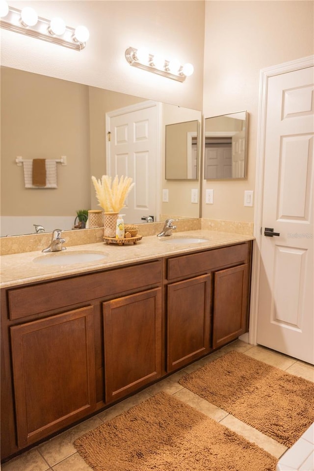 bathroom featuring tile patterned flooring, double vanity, and a sink