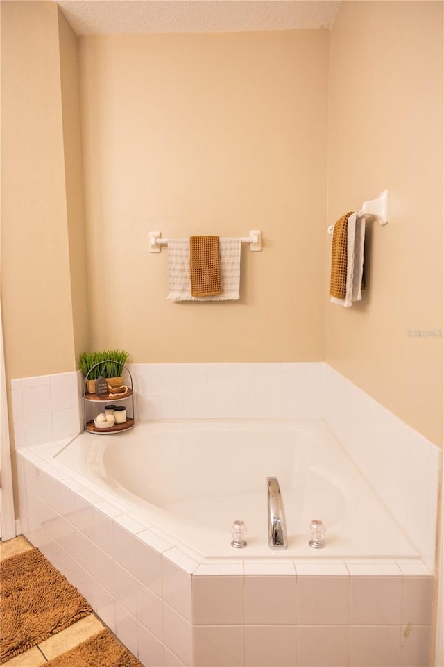 full bathroom with a textured ceiling, a bath, and tile patterned flooring