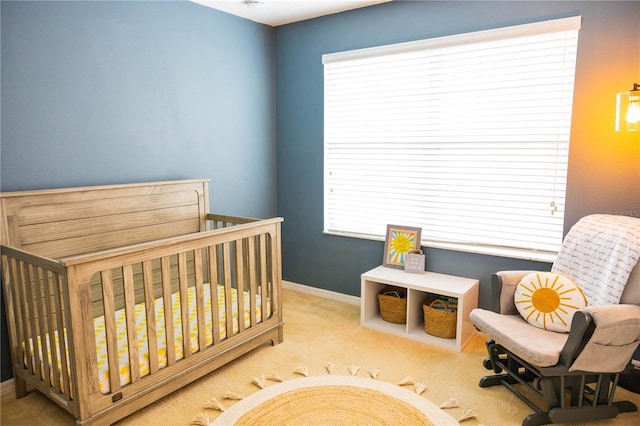 carpeted bedroom featuring multiple windows, baseboards, and a nursery area